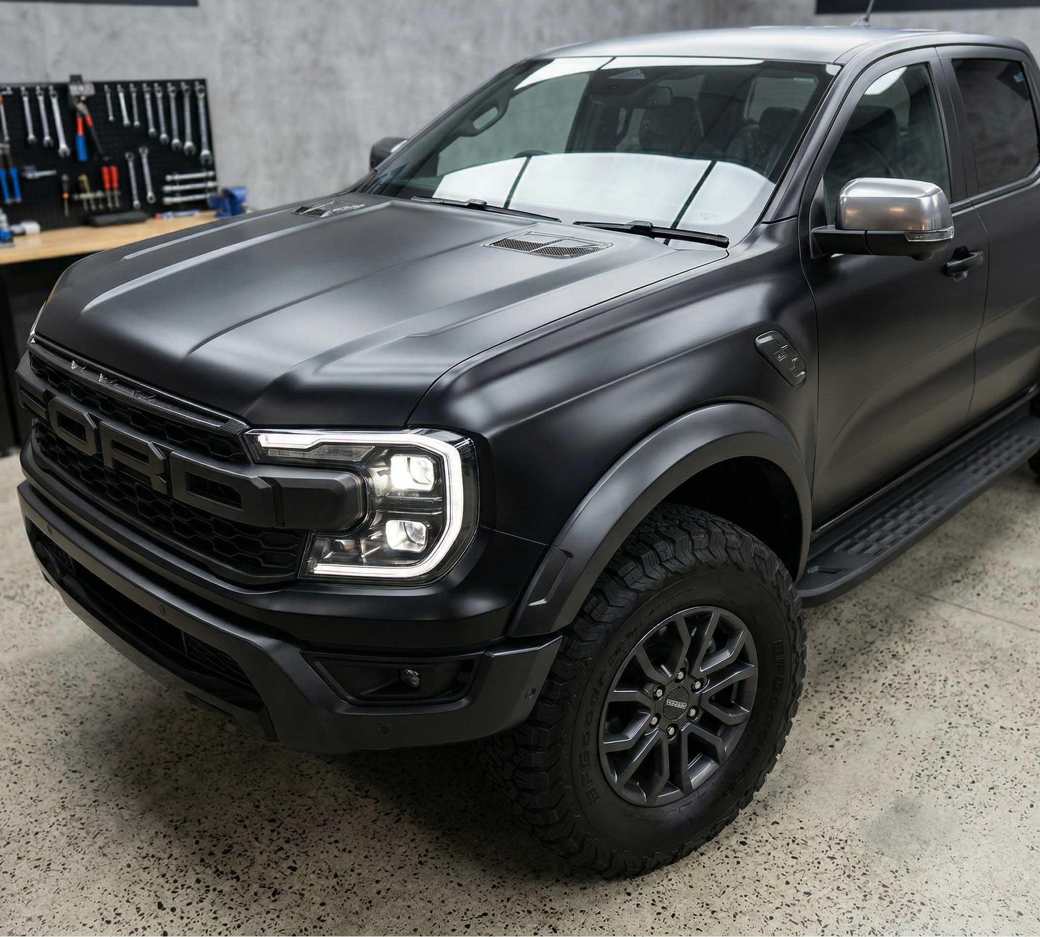 Black Ford truck in a garage with 'PRSC' branding in the background